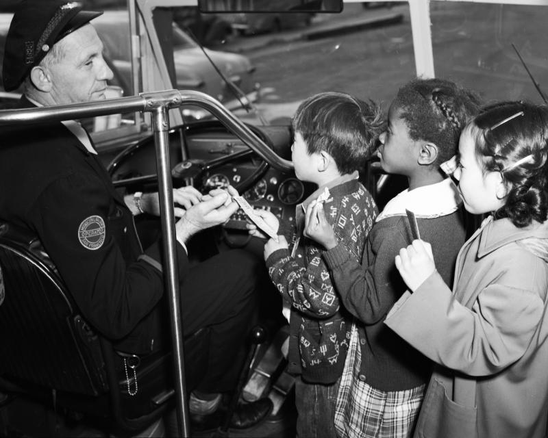 black and white photo of three children receiving transfers from Muni driver