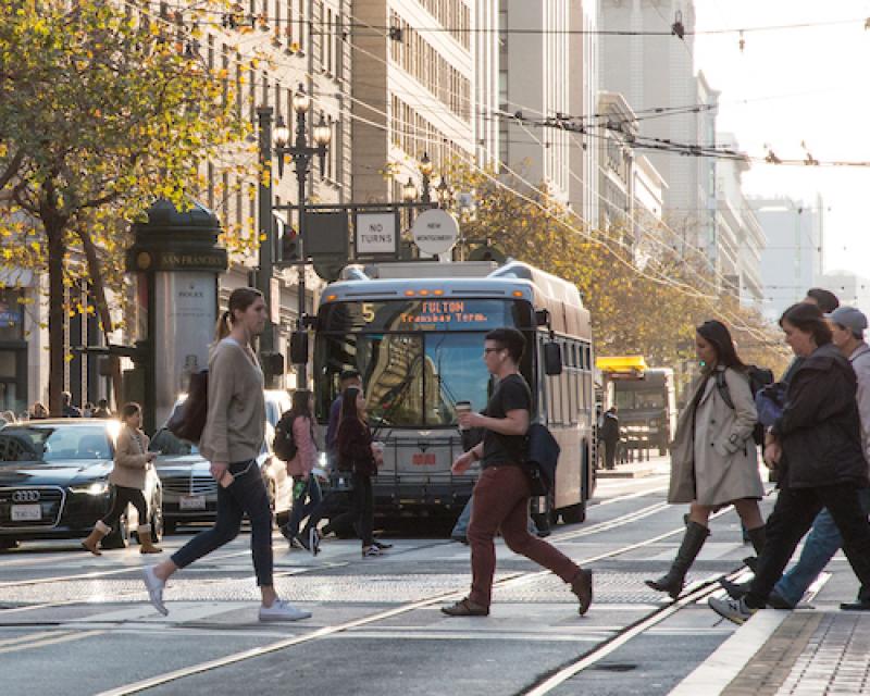 Image of a Muni Bus on Market with pedestrians in the foreground