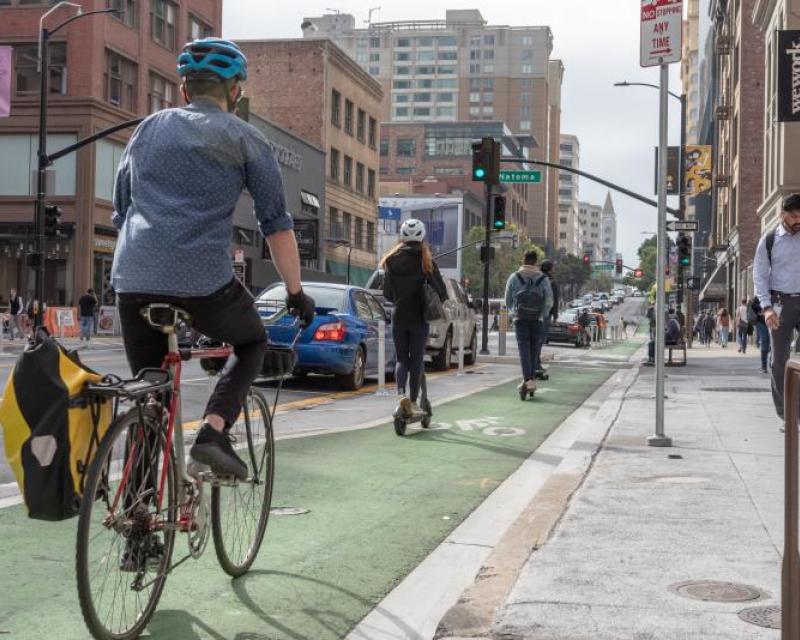 Bike and scooter riding on green bike lane