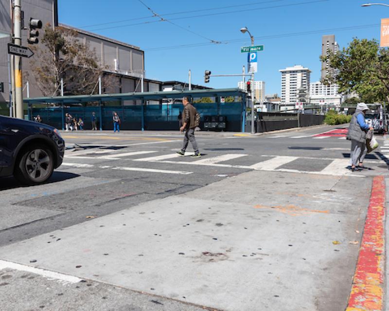 Curb painted red near an intersection to provide "daylight" and better visibility for pedestrians crossing the street.
