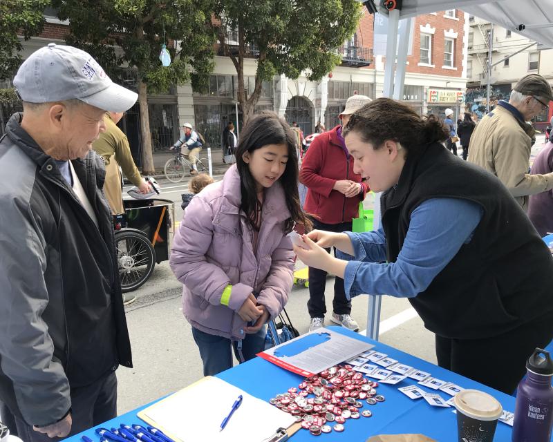 SFMTA staff showing event attendees a paper train 