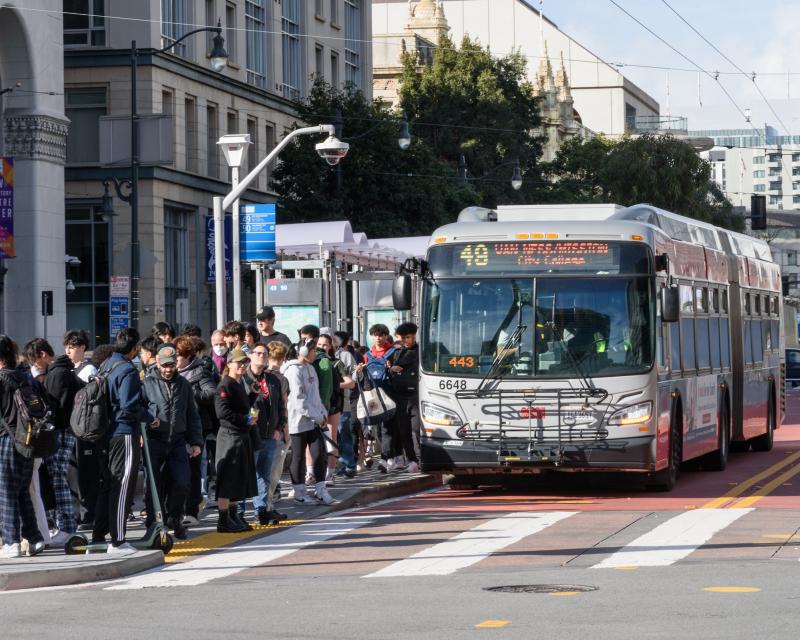 A bus at a crowded stop.