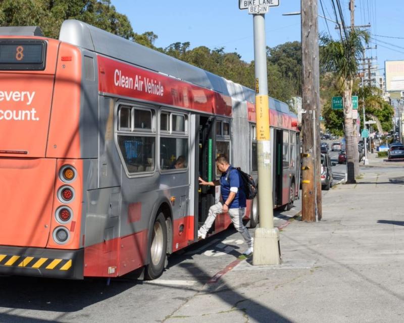 A man boards the back door of the 8 Bayshore bus at the intersection of Geneva Avenue and Santos Street in San Francisco.