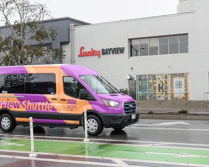 Bayview Shuttle van drives near a protected green bikeway. 
