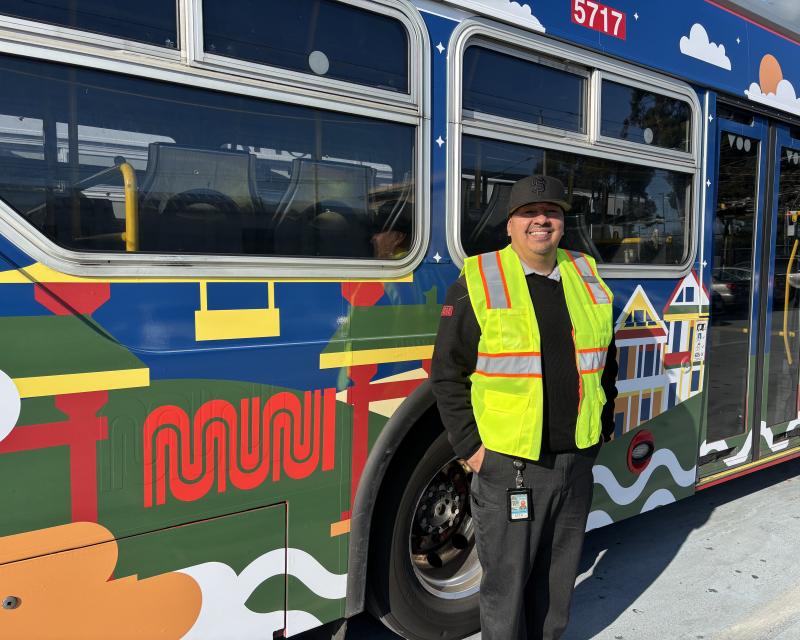 A person in front of a brightly colored bus.