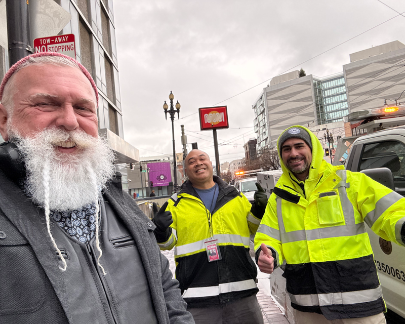 Three SFMTA staff take a fun selfie on a downtown street.