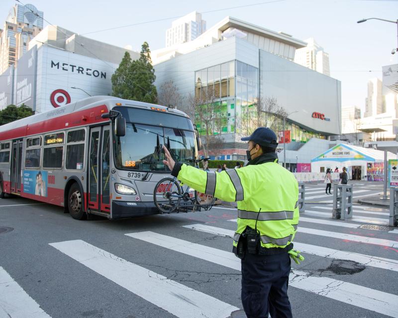 Parking control officer wearing a yellow safety vest directs traffic new Super Bowl LX events.