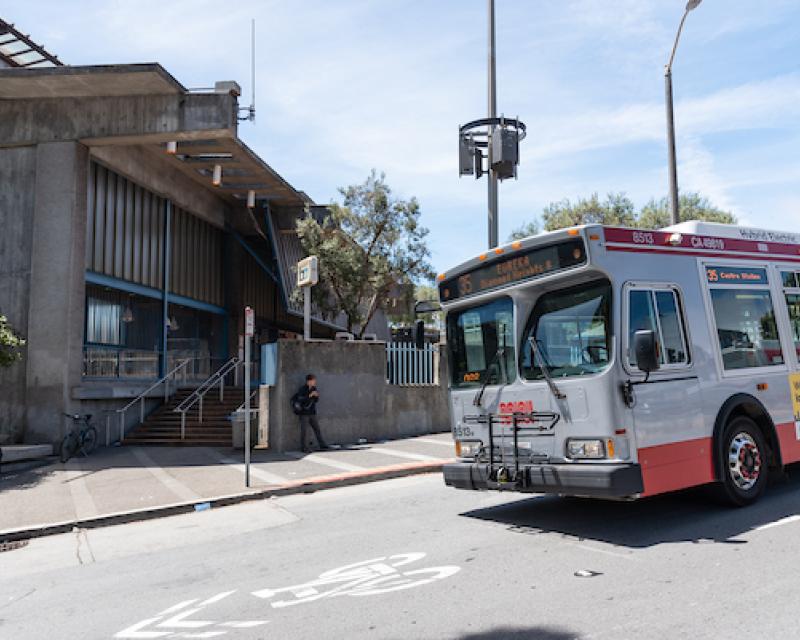 Bus on Bosworth street passing in front of the Glen park bart station . Sharrow bike roadway marking visible on Bosworth Street.