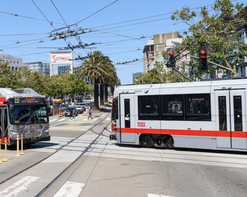 A bus and a train in an intersection.