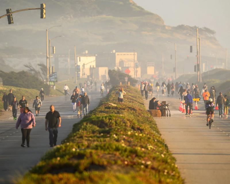 People walking and biking on Sunset dunes Park, a former divided highway. 