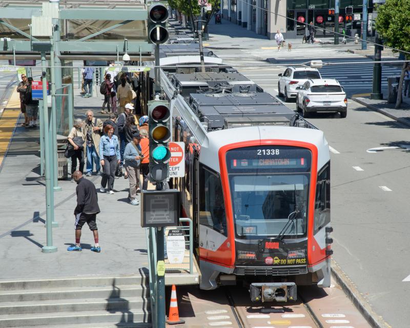 People on a transit platform boarding and exiting a train