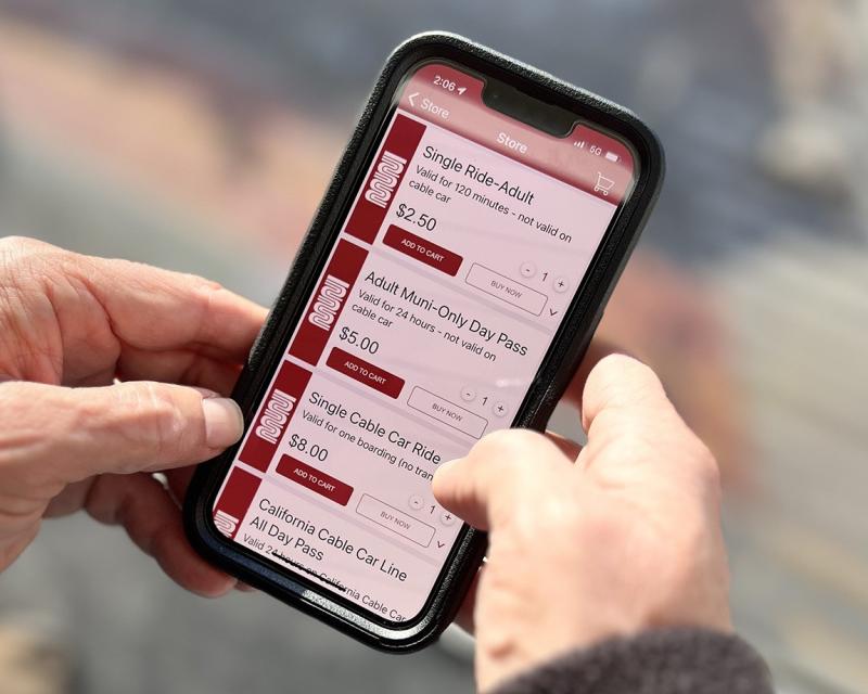 Hands holding a phone with the MuniMobile app to buy Single-Ride Adult