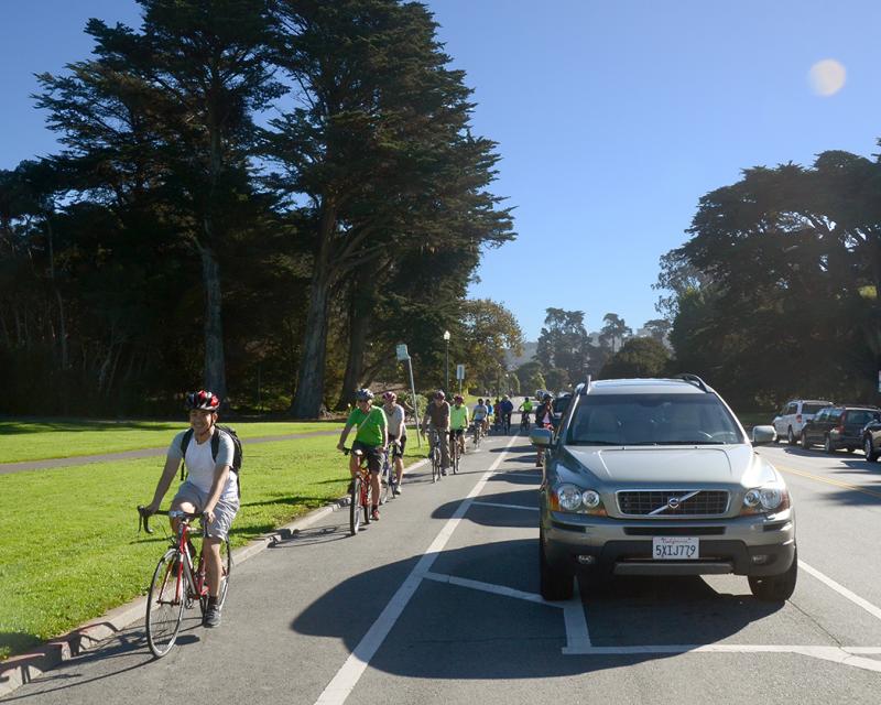 Photo of people bicycling on the parking-protected bikeway on JFK Drive.