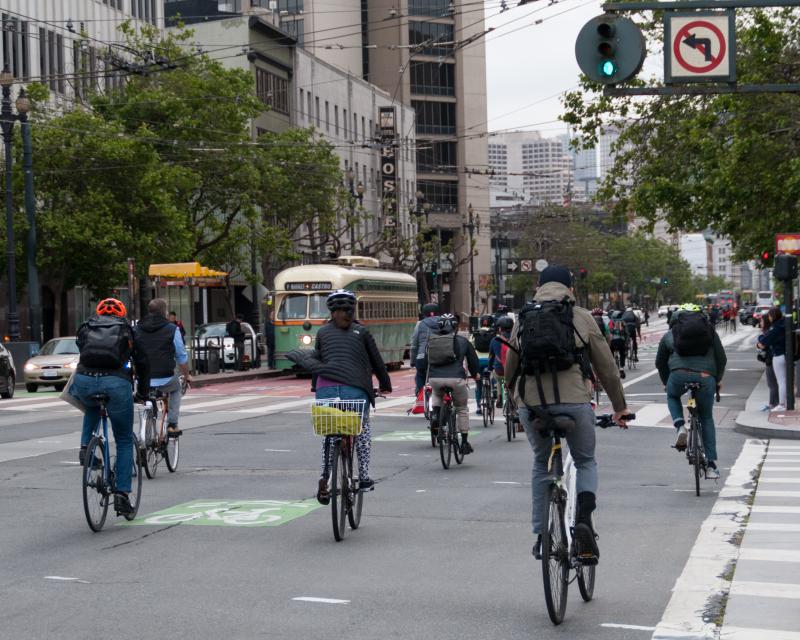 Picture of people biking on Market St crossing Van Ness Ave