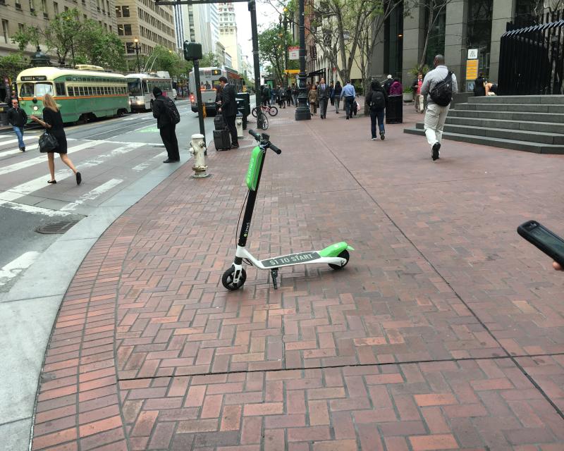 A Lime scooter parked on a Market St. sidewalk