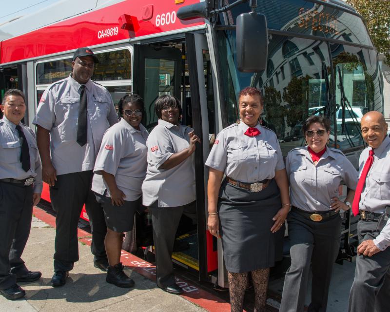 Muni operators stand alongside a bus