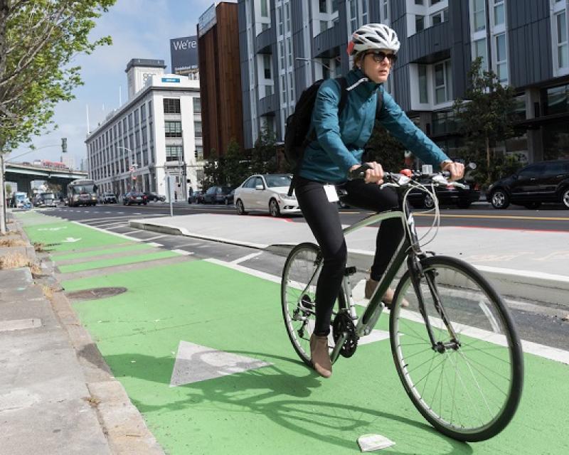 Person biking on our new protected bikeway on 8th Street.