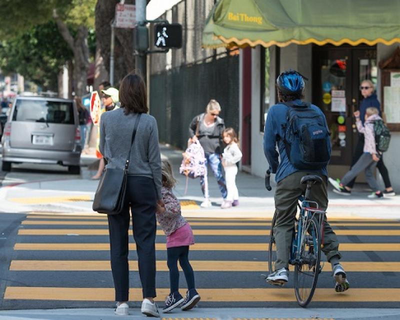 People waiting to cross at the crosswalk.
