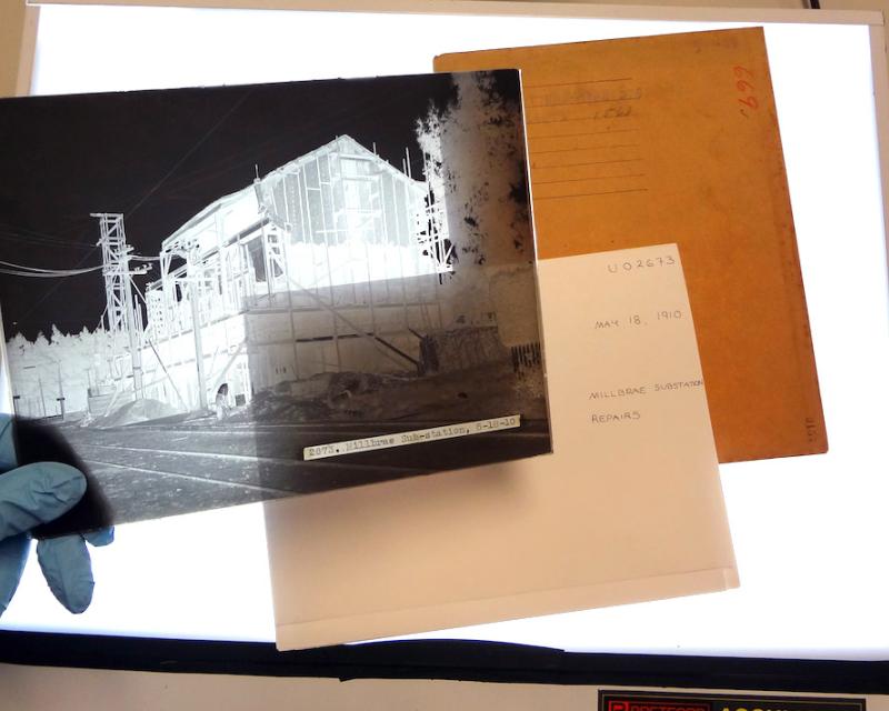 hand holding negative with envelopes behind