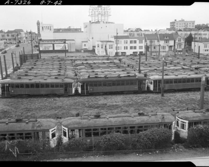 derelict streetcars sit in a large empty lot