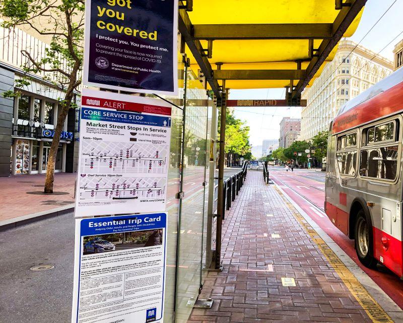 Photo of face mask, wayfinding and ETC signs at a boarding island on Market Street.