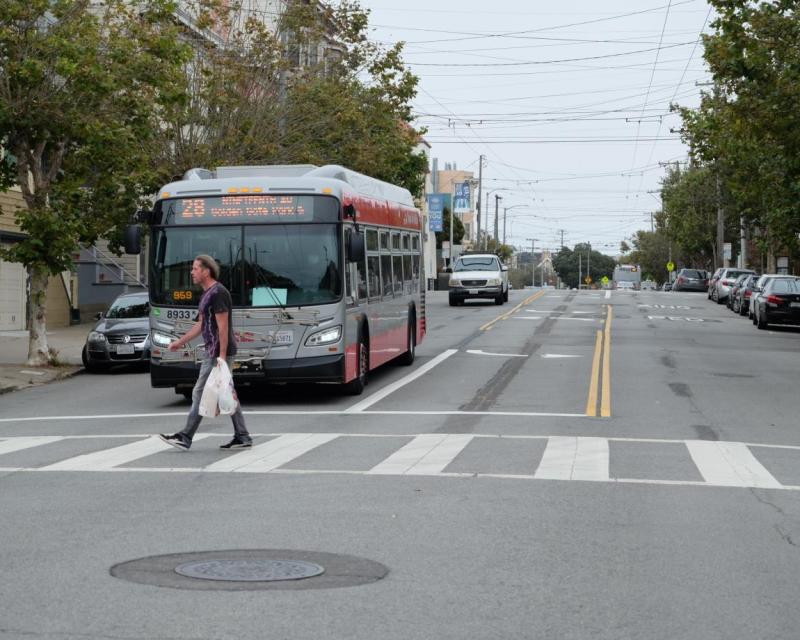 Man in crosswalk in front of a bus