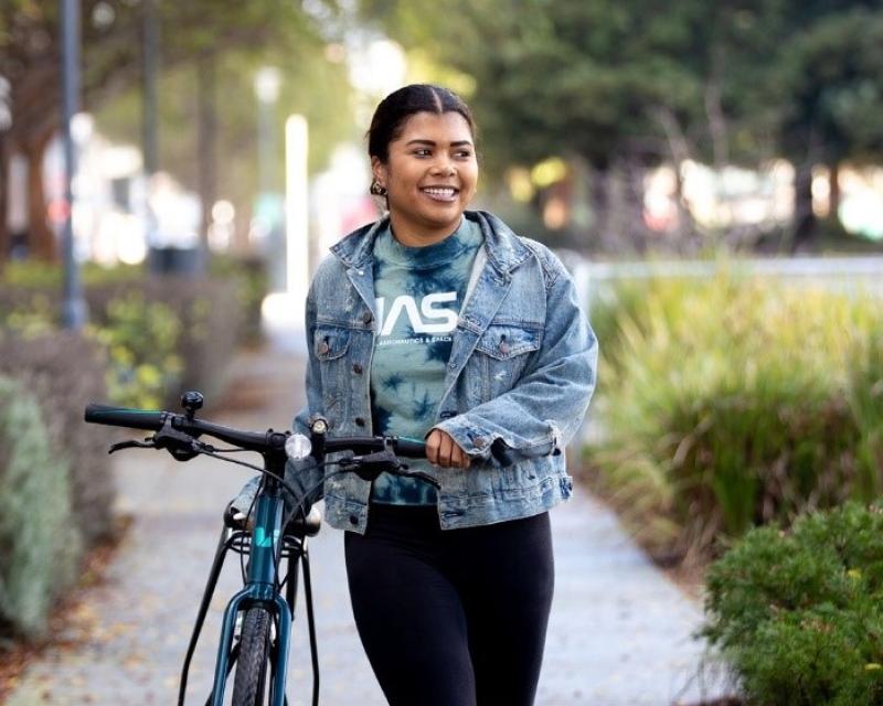 A woman walks her bike
