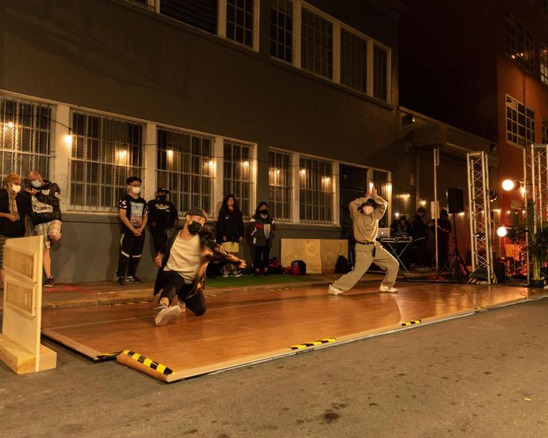 Dancers perform in an alley