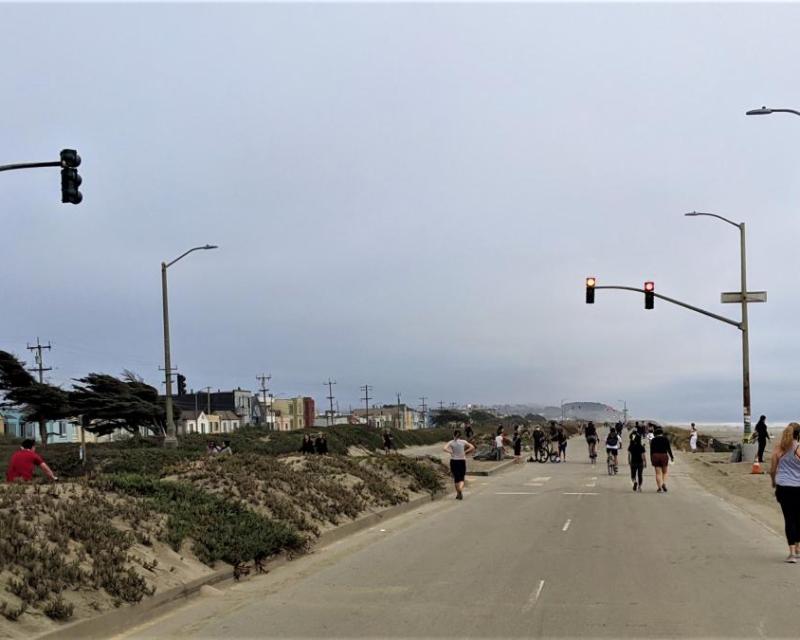 Car-free Great Highway at Noriega Street looking south with pedestrians and bicyclists next to Ocean Beach