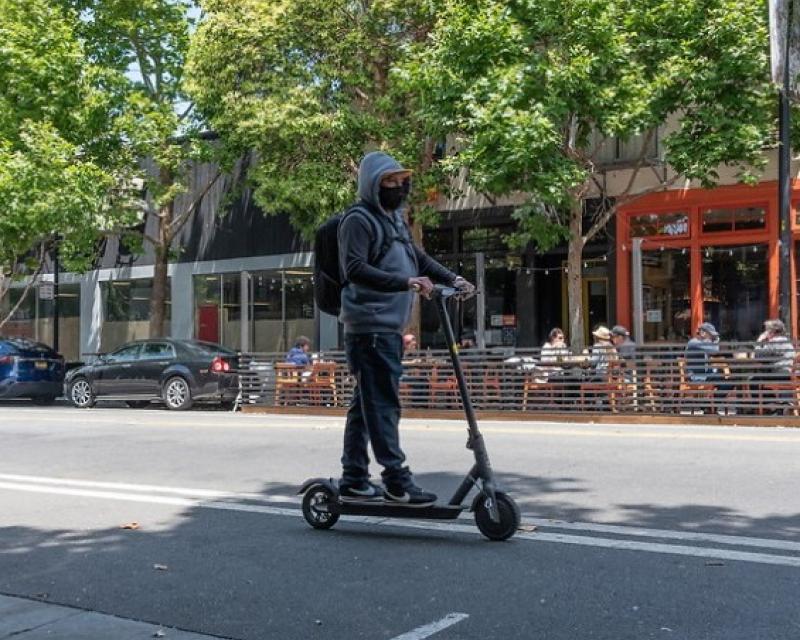 Photo of man riding scooter on Valencia Street