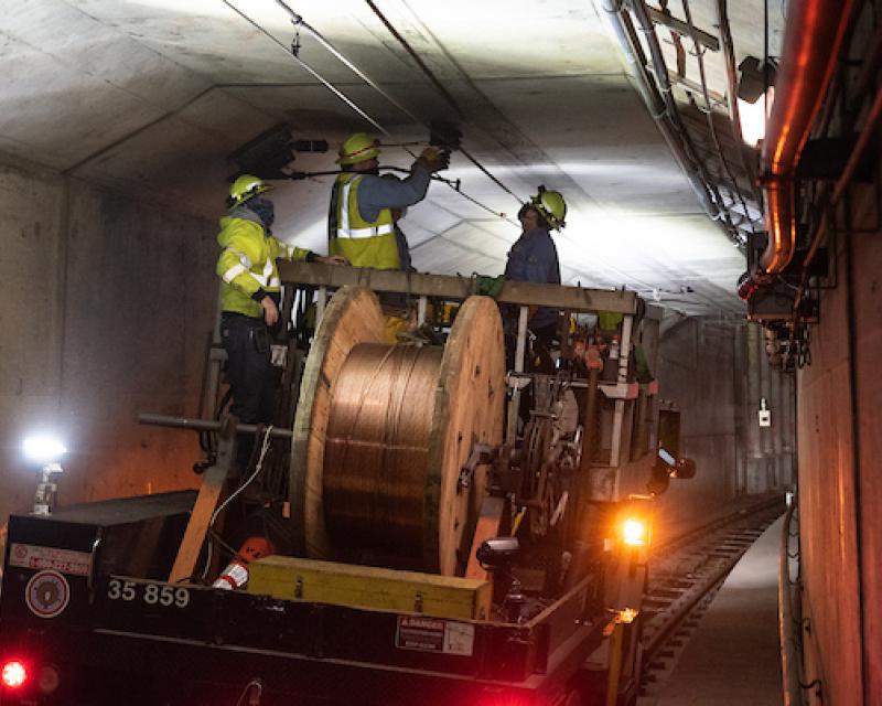 Photo of workers installing overhead wire in the subway