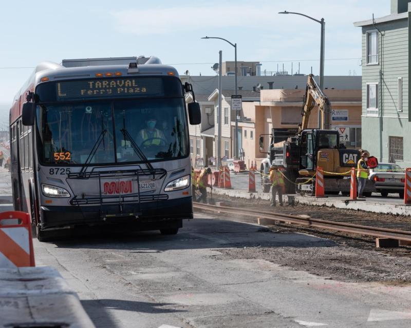 L Taravel bus passes construction of rails on Taraval Street