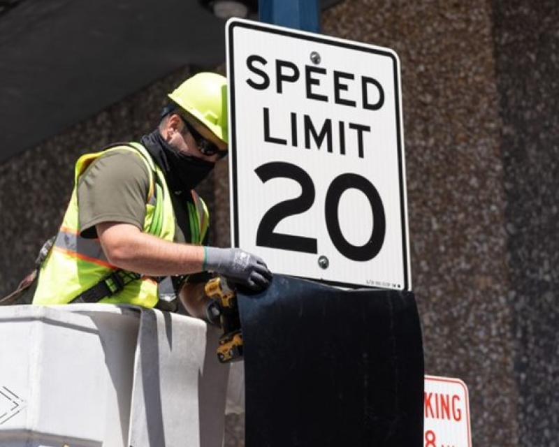 Crew member affixing a new 20 MPH speed limit on Larkin Street. 