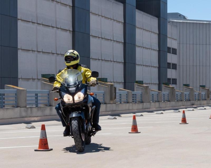 Image of motorcyclist weaving through cones during a motorcycle safety class.
