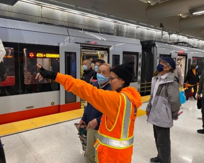 SFMTA Ambassador talking to customers on Metro station platform.