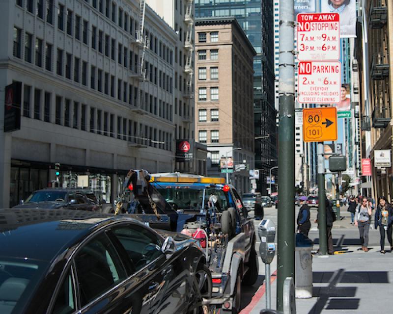 Photo of a tow truck taking away an illegally parked vehicle