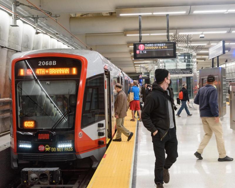 People getting on and off the light rail train at the new Union Square Station of the T-Third Central Subway