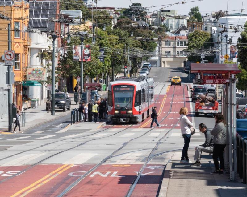 J Church using red transit lanes and picking up passengers on a boarding island on Church at Market Street. 