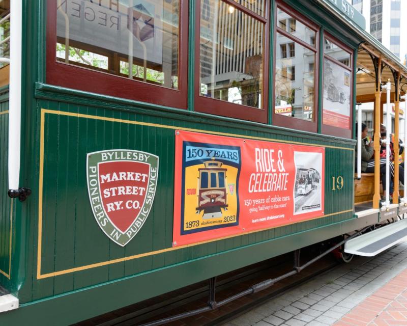 A cable car with banners for Market Street Railway Co. and 150 years of the Cable Cars.