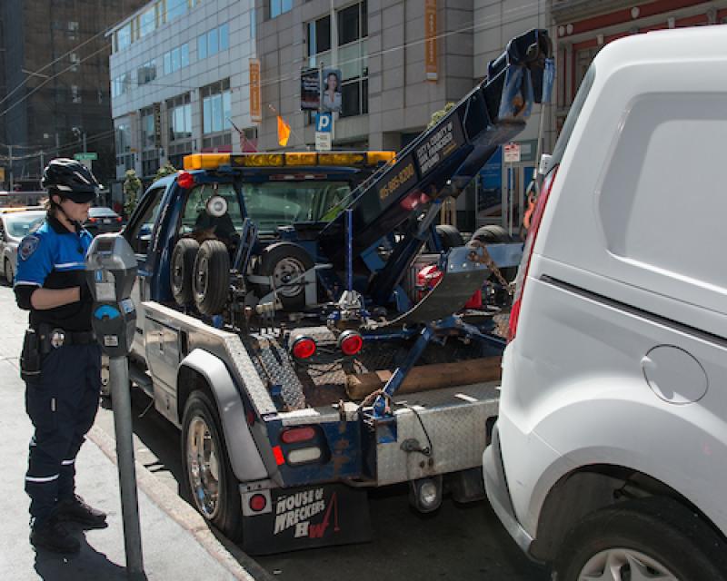 Tow truck towing vehicle Parking Control officer present 