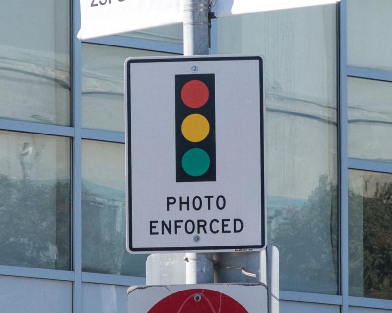 Traffic sign with an image of a traffic signal and the words photo enforced