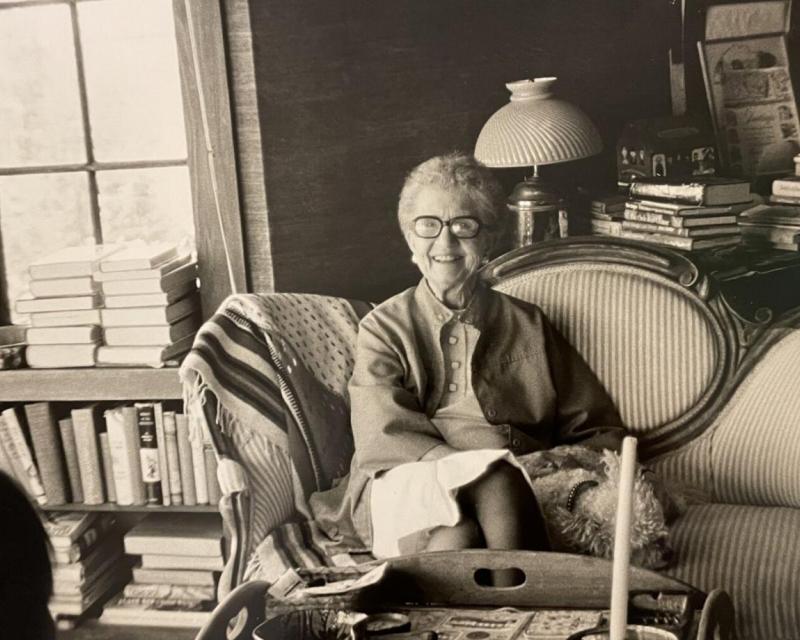 A black and white photo of Friedel Klussman, an activist who fought to save the cable cars. She smiles from a living room.