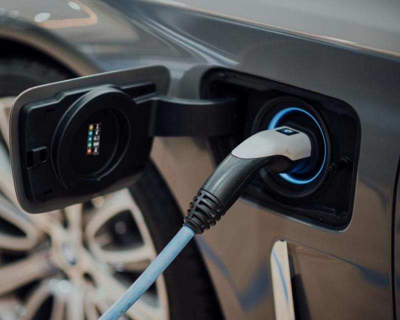 Photograph of charger connected into a personal vehicle. Photo by CHUTTERSNAP on Unsplash