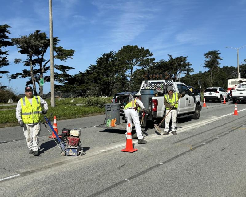 A group of men in safety vests on a road