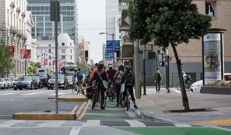 Bike commuters in a protected bike lane on Polk Street at Hayes Street on Bike to Work Day 2016.