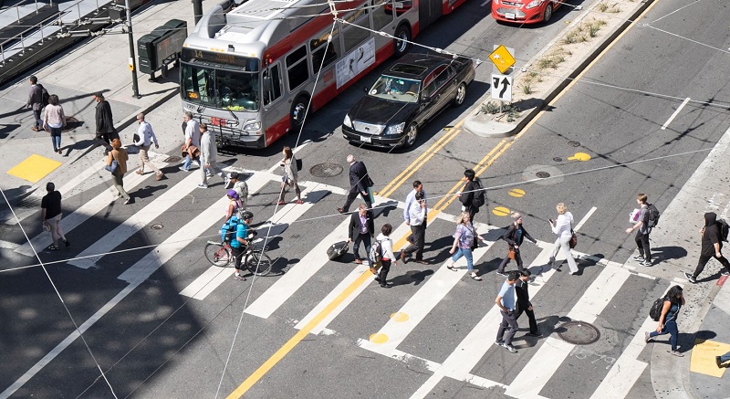 A bustling crosswalk, cars and Muni buses at Mission and 4th streets.