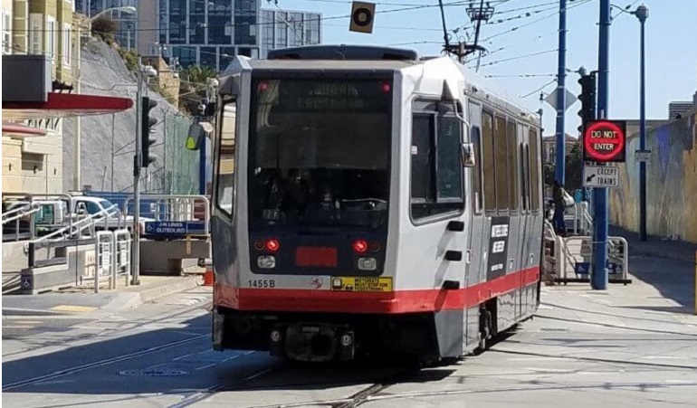 An N Judah Muni Metro train enters the subway portal at Duboce Avenue and Church Street.