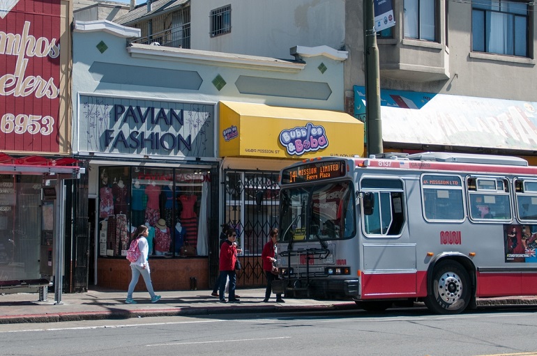 A 14 Mission Muni trolley bus stopped in front of local shops in the Excelsior district.