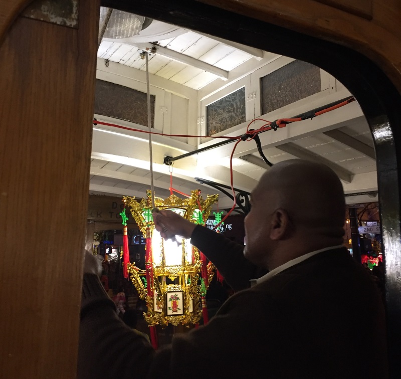 Leonard Oats rings the cable car bell as the rubber-tire cable car makes its way through the Chinese New Year Parade.