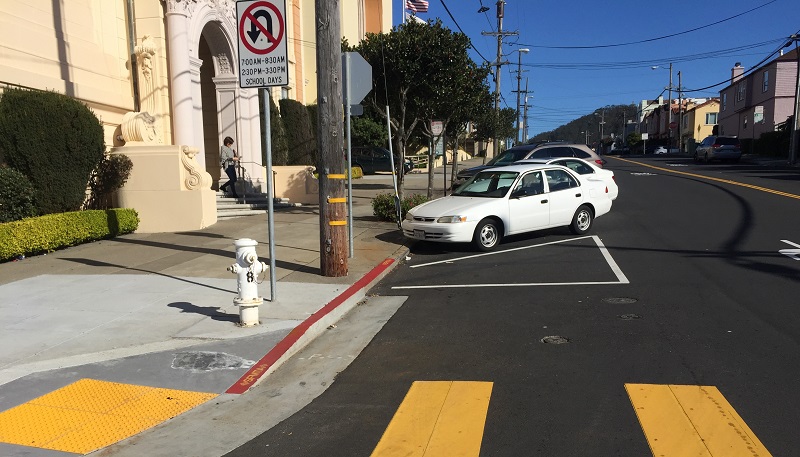 A corner on Vicente Street with existing “front-in” angled parking and “daylighting.”